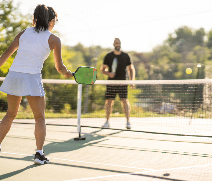 Man and woman playing pickle ball outside