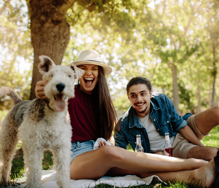 Couple outside at a dog park with their fur baby 